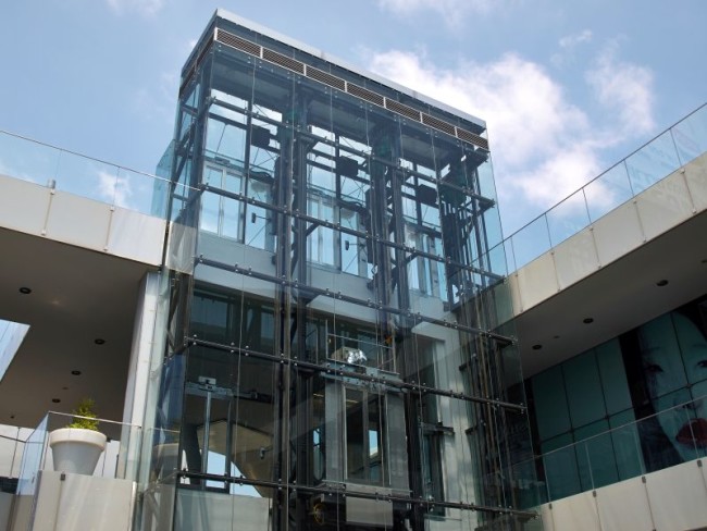 Modern design transparent glass elevator in an office building