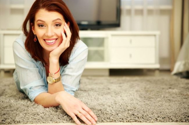 26067445 - smiling woman lying on the floor at home