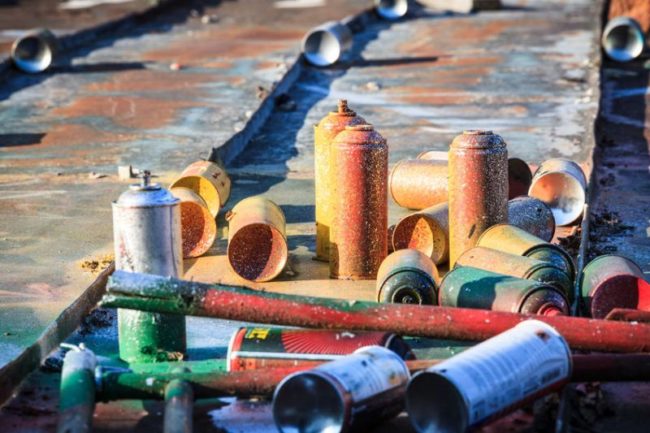 43040736 - used graffiti spray cans laying around at roof of abandoned warehouse
