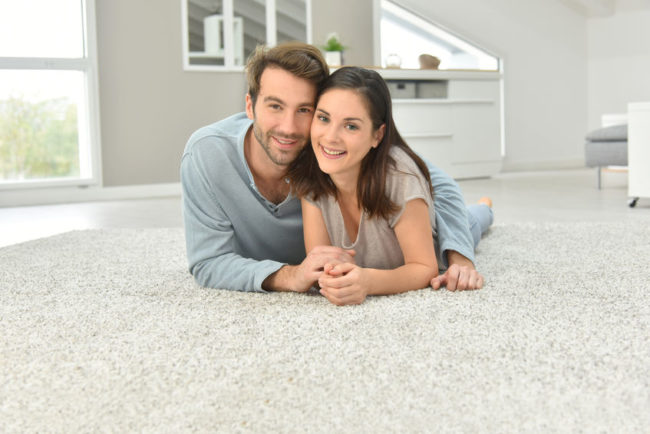 47872704 - couple laying on carpet in living room
