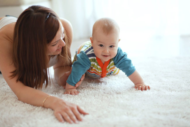 23962945 - mother with her baby playing on a carpet at home